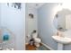 Cozy half bathroom featuring a modern pedestal sink, toilet, and charming decor at 6100 Paducah Dr, Raleigh, NC 27610