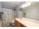 Bathroom with a large mirror, wood cabinets, shower, and toilet at 6100 Paducah Dr, Raleigh, NC 27610