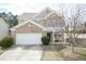 Charming two-story home featuring a brick and siding facade, attached garage, and a cozy covered front porch at 6100 Paducah Dr, Raleigh, NC 27610