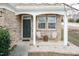 Charming front porch featuring comfortable seating, elegant brickwork, and a welcoming entrance to the home at 6100 Paducah Dr, Raleigh, NC 27610