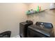 Laundry room with modern, dark-colored Samsung washer and dryer units at 6100 Paducah Dr, Raleigh, NC 27610