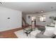 Open-concept living area with natural light, showcasing a cozy sofa, staircase, and seamless flow to adjacent spaces at 6100 Paducah Dr, Raleigh, NC 27610