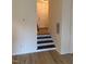 Inviting entryway with sleek black and white stairs, and light-colored wood floors at 6102 Highcastle Ct, Raleigh, NC 27613