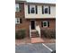 Charming brick townhouse with black shutters and a welcoming entryway staircase at 6102 Highcastle Ct, Raleigh, NC 27613