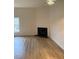 Bright living room with a cozy fireplace and modern light-colored wood floors at 6102 Highcastle Ct, Raleigh, NC 27613