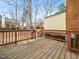 Wooden backyard deck overlooking the yard in a property with beautiful trees and a brick facade at 6469 New Market Way, Raleigh, NC 27615