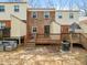 Townhome backyard with a deck and patio surrounded by mature trees at 6469 New Market Way, Raleigh, NC 27615