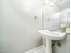Bright bathroom featuring a pedestal sink, gold fixtures, and a well-lit mirror at 6469 New Market Way, Raleigh, NC 27615