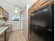Efficient kitchen with oak cabinets and black appliances, plus a ceiling fan at 6469 New Market Way, Raleigh, NC 27615