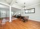 Open living room with hardwood floors, columns, neutral walls, and a dining table at 6469 New Market Way, Raleigh, NC 27615