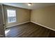 This bedroom features hardwood floors, a window for natural light, and neutral paint at 7036 Barlows Knoll St, Raleigh, NC 27610