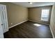 Neutral bedroom with wood-look floors, a large window, and plenty of natural light at 7036 Barlows Knoll St, Raleigh, NC 27610