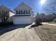 Charming two-story home with a spacious two-car garage and a well-maintained front yard on a sunny day at 7036 Barlows Knoll St, Raleigh, NC 27610