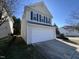 Two-story home featuring a two-car garage, complemented by green shutters and a well-manicured lawn at 7036 Barlows Knoll St, Raleigh, NC 27610