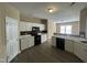 Well-lit kitchen with white cabinets, modern appliances, mosaic backsplash, and stylish flooring at 7036 Barlows Knoll St, Raleigh, NC 27610