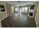 Open living room with modern floors, a fireplace, and ample natural light from large windows at 7036 Barlows Knoll St, Raleigh, NC 27610
