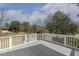 Spacious wooden deck with white railing overlooking a peaceful, tree-lined backyard at 75 Morgan Dr, Lillington, NC 27546