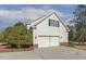 Exterior shot of the home's two-car garage, framed by a manicured yard and blue skies at 75 Morgan Dr, Lillington, NC 27546