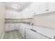 Functional laundry room featuring tile flooring, white cabinetry, sink and a freezer at 75 Morgan Dr, Lillington, NC 27546