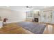 Open living room with fireplace, hardwood floors, and light-filled windows with views of the back yard at 75 Morgan Dr, Lillington, NC 27546