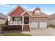 Charming two-story brick home with red accents, a cozy front porch, and a well-manicured lawn at 836 Canyoncreek Ln, Fuquay Varina, NC 27526