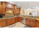 Gourmet kitchen featuring granite countertops, stainless steel appliances, and wood cabinets overlooking the dining area at 836 Canyoncreek Ln, Fuquay Varina, NC 27526