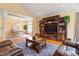 Spacious living room with an entertainment center, wood floors, a stylish rug, and comfortable leather furniture at 836 Canyoncreek Ln, Fuquay Varina, NC 27526