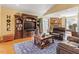 Cozy living room with custom built-ins, a stone fireplace, comfortable furniture, and wood flooring at 836 Canyoncreek Ln, Fuquay Varina, NC 27526