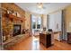Cozy office space with a stone fireplace, natural light, a wooden desk, and wood flooring at 836 Canyoncreek Ln, Fuquay Varina, NC 27526