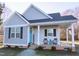 Charming home featuring gray siding, black shutters, and a welcoming front porch with rocking chairs at 103 1St St, Haw River, NC 27258