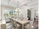 Elegant dining room with large windows, coffered ceilings and stylish chandelier at 123 Stone Park Dr, Wake Forest, NC 27587
