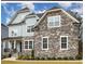 Stunning two-story home featuring stone accents, a landscaped yard, and inviting front entrance at 123 Stone Park Dr, Wake Forest, NC 27587