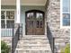 Inviting entrance with beautiful wooden double doors and stone steps leading to the charming front porch at 123 Stone Park Dr, Wake Forest, NC 27587