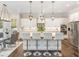 Open-concept kitchen with an island, pendant lighting, and stainless steel appliances, perfect for entertaining at 123 Stone Park Dr, Wake Forest, NC 27587