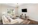 Cozy living room with stylish furniture, a modern light fixture, and natural light, creating a relaxing ambiance at 123 Stone Park Dr, Wake Forest, NC 27587