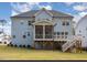 Backyard view of a two-story home with a screened porch, deck, and well-maintained lawn at 123 Stone Park Dr, Wake Forest, NC 27587