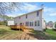 View of the home's backyard featuring a deck, lush lawn, and mature trees at 12409 Village Gate Way, Raleigh, NC 27614