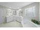 Primary bathroom with double sinks, soaking tub, lots of natural light, and tiled floor at 12409 Village Gate Way, Raleigh, NC 27614