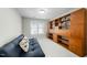 Cozy room featuring a built-in bookshelf, a comfortable blue futon, and a large window at 12409 Village Gate Way, Raleigh, NC 27614