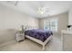 Bright bedroom with a white carved headboard, purple patterned comforter, and matching end table at 12409 Village Gate Way, Raleigh, NC 27614