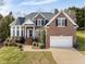 Charming two-story brick home with manicured lawn and attached two car garage at 12409 Village Gate Way, Raleigh, NC 27614