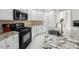 Close-up of the kitchen with granite counters, white cabinets, and stainless steel appliances at 12409 Village Gate Way, Raleigh, NC 27614