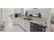 Close-up of the kitchen featuring granite counters, white cabinets, and stainless steel appliances at 12409 Village Gate Way, Raleigh, NC 27614