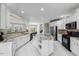 Open-concept kitchen with white cabinets, granite countertops, stainless steel appliances, and tile flooring at 12409 Village Gate Way, Raleigh, NC 27614