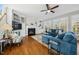 Bright living room featuring hardwood floors, fireplace, built-in shelves, and a comfortable blue sofa at 12409 Village Gate Way, Raleigh, NC 27614