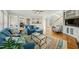 Open-concept living room with view to kitchen, a blue sofa, fireplace and hardwood floors at 12409 Village Gate Way, Raleigh, NC 27614
