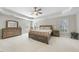 Spacious primary bedroom featuring tray ceiling, large bed, matching nightstands and furniture set at 12409 Village Gate Way, Raleigh, NC 27614