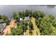 Stunning aerial view of a lakefront home surrounded by lush greenery and mature trees at 1315 Sagamore Dr, Louisburg, NC 27549