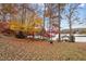 Backyard view in autumn showcasing colorful trees, a serene lake, and a charming boathouse at 1315 Sagamore Dr, Louisburg, NC 27549