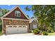 Home exterior featuring stone facade, manicured lawn, and two-car garage at 1315 Sagamore Dr, Louisburg, NC 27549